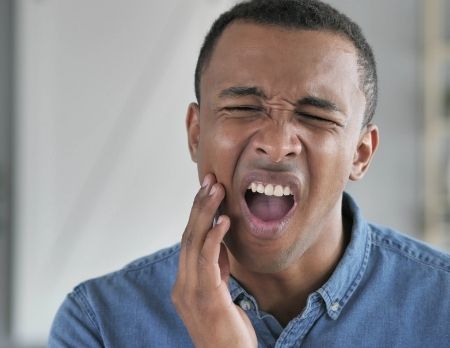 Young African American man portraying the need for wisdom teeth removal