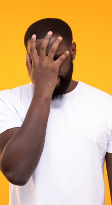 Black man covering his face, portraying trouble with dental crowns and his bite is off